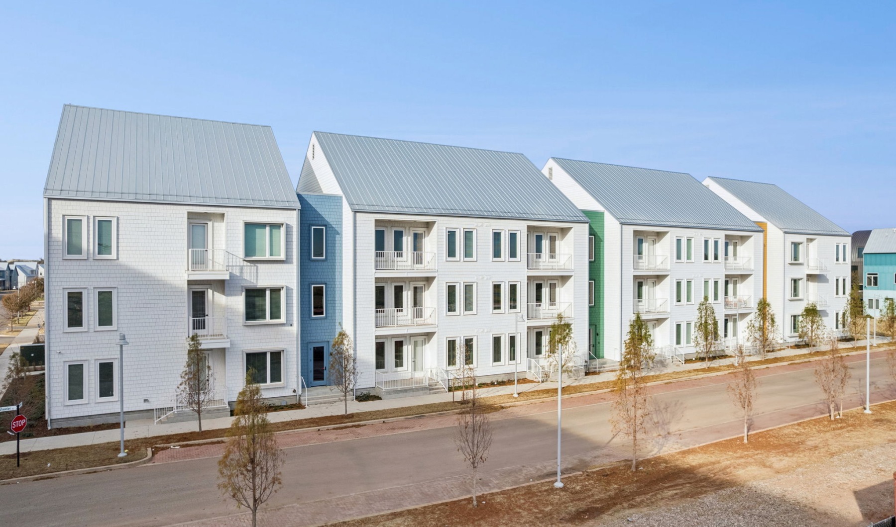 outside of a white apartment building with trees