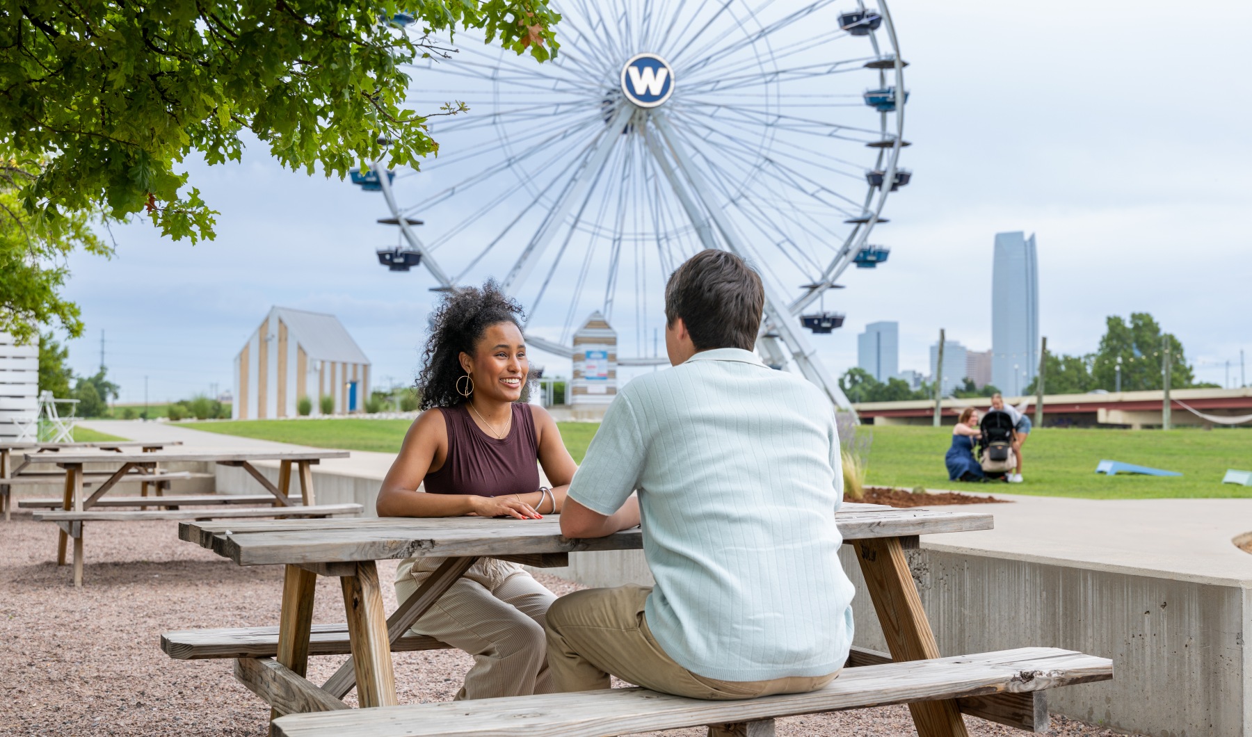 two people sitting at a picnic table in downtown okc